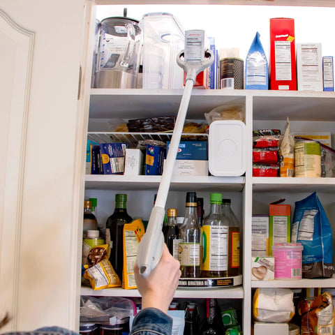 Unger 32-inch reacher/grabber tool with white handle and gray head, used to grab items from pantry shelves.