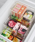 Kick Clutter To The Curb With These 8 Pack Freezer Organizer Bins Featuring Reinforced Handles And Thickened Food Grade Plastic For Fridge Pantry Storage That Really Keeps Your Kitchen Game Strong, showing stacked clear bins storing various frozen foods.