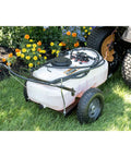Tow-Behind Garden Sprayer With 15 Gallon Tank, 30 Inch Boom, 1.6 GPM At 100 PSI on grass beside flowers and tractor