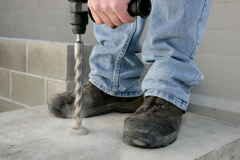 Worker using Fixed-Depth Bit MDPL050DIA For Three Eighths Inch Drop-In Anchors on concrete, ensuring precise depth control.