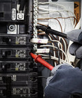 Hands using TL809 Electronic Test Lead Kit with probes on circuit breaker panel for maintenance