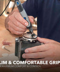 Close-up of Dremel Stylo+ engraving pen with slim gray grip used on a camera lens mount.