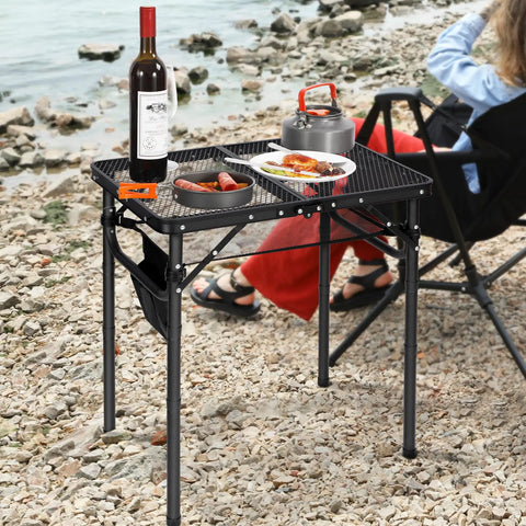 Small Folding Grill Table For Outdoors With Three Adjustable Heights Lightweight Portable Aluminum Camp Table Black 24x16 Inches on a rocky beach with food and drinks