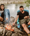 People relaxing by campfire on Low Beach Chair With Mesh Back And Cup Holder, Foldable Camp Chair For Outdoor Use