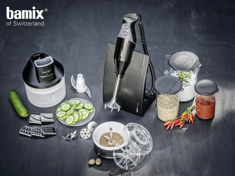 Game Changing One Liter Blending Pitcher With Comfortable Handle Crisp Graduations BPA Free with immersion blender and ingredients on table.