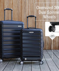 Front view of Samsonite Omni 2 24-inch medium hardside luggage with 360° spinner wheels; two navy suitcases.