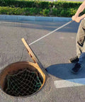 Man using No Sweat Heavy Duty Manhole Cover Lift Hook With T Shaped Steel Puller For Drain Well Lid Opener to open drain lid.