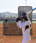 L Screen Baseball Pitching Net With Wheels, 7x7 Ft Heavy Duty Portable Steel Frame used during batting practice on a field