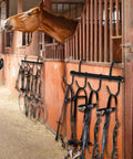 Two Pack Black Tack Rack With 360 Degree Swivel Hooks For Horse Bridle Hangers Portable Stall Barn Fence Trailer Organizer Six Hook Horse Gear Storage mounted in a stable with horse gear.