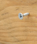 Hella Tough Phillips Flat Head Wood Screws Assortment Kit With Driver Bit, Heavy Duty Self Tapping Fasteners embedded in wood.