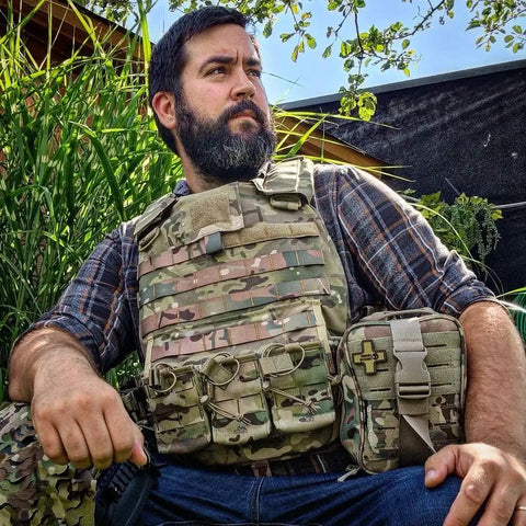 Man in tactical gear with IFAK Trauma Kit With CAT Tourniquet And Israeli Bandage Wound Care Essentials in MOLLE pouch outdoors.
