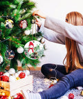 Person decorating tree with 40 Pack Double Sided Metal Sublimation Ornament Blanks For Christmas Tree Decor And DIY Crafts