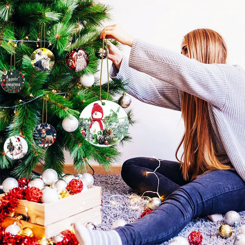 Person decorating tree with 40 Pack Double Sided Metal Sublimation Ornament Blanks For Christmas Tree Decor And DIY Crafts
