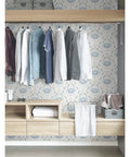 Blue Shellby Peel And Stick Wallpaper with Coastal Crab Damask Print in a closet setting with hanging clothes and shelves.