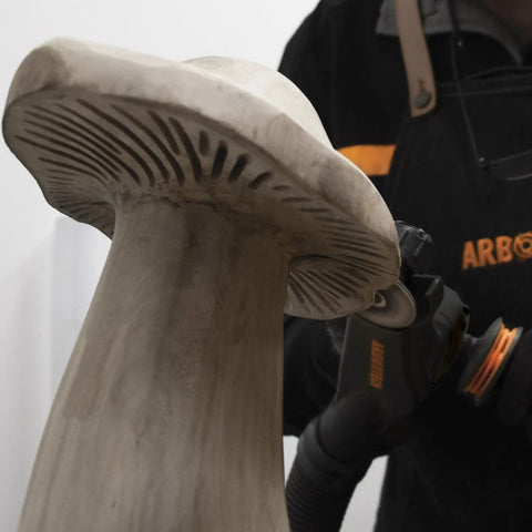 Close-up of mushroom sculpture being refined with No Nonsense Heavy Hitter 8 Amp Mini Wood Carving Router for detailed work.