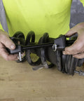 Hands using MacPherson Strut Coil Spring Compressor Tool For Safe And Easy Spring Compression Pro Grade Durable Construction