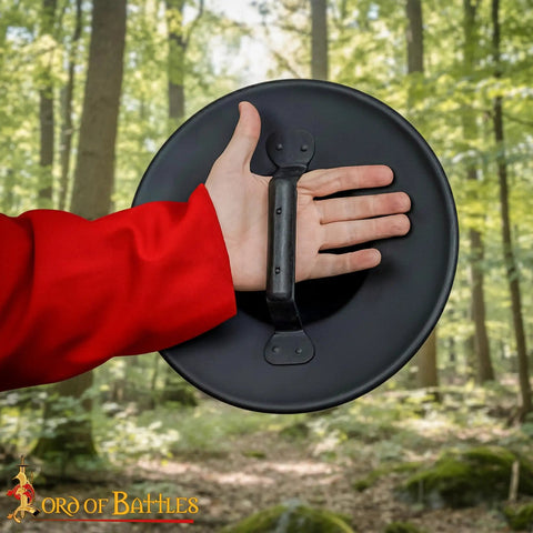 Old School Medieval Steel Buckler Shield Handcrafted With Wooden Grip, 16 Gauge, 30 Cm Round Shield held in forest.