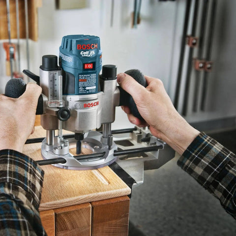 Person using Bosch router tool on wood surface in workshop setting