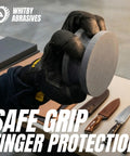 Person holding 4 Inch Dual Grit Pro Grade Axe And Hatchet Sharpener Silicon Carbide Stone with gloves, showing safe grip feature.