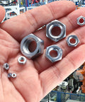 Assorted Stainless Steel Hex Nuts Kit With 430 Pieces, Coarse Thread Nut Set shown in hand over industrial background