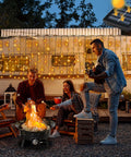 Evening scene with people enjoying a campfire and Solar Curtain Lights Outdoor 200 LED Set, 13Ft by 3.3Ft on a camper.