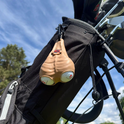 Funny Golf Gift Set With Ball Holder Silicone Pouch, 2 Golf Balls, attached to black golf bag