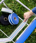 Revamp Your Worn Out Lawn Chairs With This Heavy Duty Replacement Webbing Kit Featuring UV Resistant Polypropylene Straps laid out beside a chair.