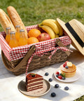 Dual Size Picnic Basket Set With Double Folding Handles 16 Inch Woodchip Woven Basket With Removable Red And White Liner For Weddings Camping Outdoor Use Candy And Egg Gathering Storage filled with bread, fruit, and drinks on a picnic blanket.