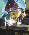 Welding in progress on mobile welding table with firm grip handle and heavy duty swivel casters for metal fit up kit