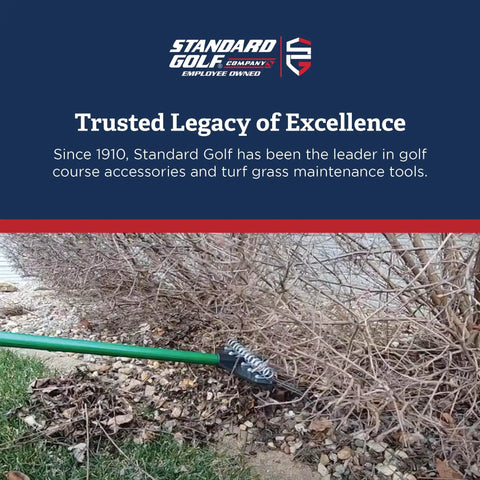 Garden rake clearing debris from under bushes next to a lawn, showcasing tools for turf grass maintenance by Standard Golf.