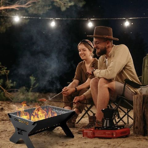 Couple using Portable Folding Charcoal Grill For Outdoor Cooking And Campfires Lightweight Fire Pit With Carry Bag at night