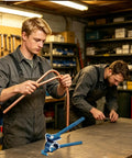 Real Deal Manual Tube Bender For Copper And Steel Pipes Ergonomic Long Handle being used to bend copper pipe indoors.