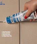 Hand using Tile Grout Repair Kit Squeeze Tube Fast Drying Waterproof Grout Paint to Restore and Renew Tile Joints for Bathroom Kitchen Shower Floor Tiles Grey 8.8 Oz With Precision Spatula and Easy Application for Diy Renovations on tile joint.
