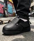 Heavy Duty Steel Toe Shoe Covers With Adjustable Strap Safety Overshoes For Work, black protective footwear on asphalt.