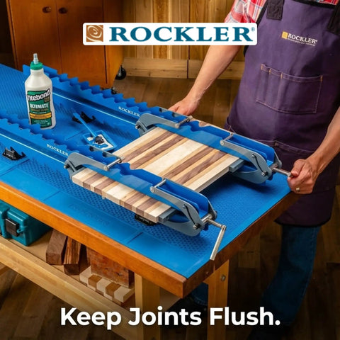 Woodworker using Deluxe Panel Clamps With Scissor Couplers for flat panels and flush joints on a tabletop, precise alignment.