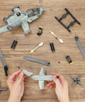 Hands assembling Desert Camouflage Viper Attack Helicopter Building Block Set with 597 Pieces, dual rotors visible on table