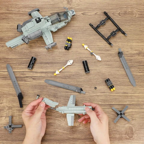 Hands assembling Desert Camouflage Viper Attack Helicopter Building Block Set with 597 Pieces, dual rotors visible on table