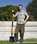 Man holding Heavy Duty Garden Shovel With 56 Inch Round Blade And Fiberglass Handle In Orange For Tough Digging And Yard Work Pro Grade Non Slip Grips For Comfort And Control