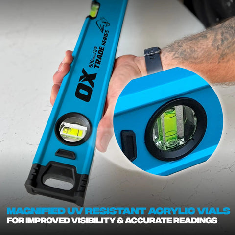 Person holding Pro Grade 2 Foot Aluminum Level Box Beam with magnified vials for precise 0.0005 in/in accuracy use on concrete.