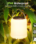 IP44 water-resistant Powerful 1000LM LED Camping Lantern With Rechargeable Battery hanging amid rainy foliage