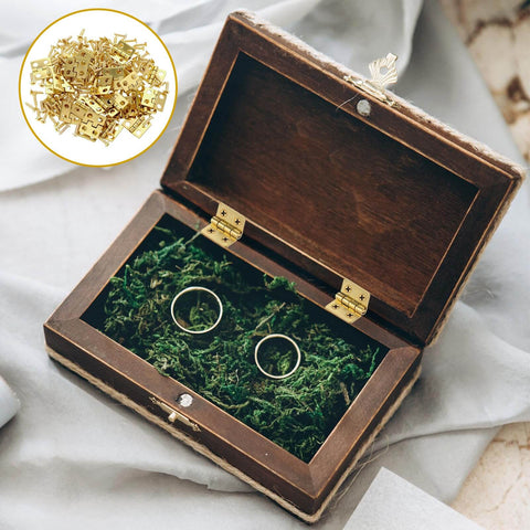 Gold Mini Hinges Set 30 Piece Tiny 13x12mm Brass Butt Hinges With 180 Degree Rotation For Wooden Boxes Jewelry Boxes Dollhouses And DIY Projects Includes Screws For Tiny Builds shown installed on a wooden box with rings inside.