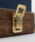 Close-up of Retro Hasp Latches With Toggle Catch Lock For Antique Wood Boxes on wooden box, durable gold metal finish.