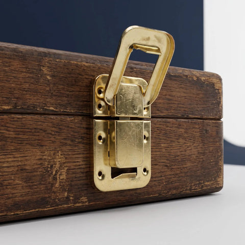 Close-up of Retro Hasp Latches With Toggle Catch Lock For Antique Wood Boxes on wooden box, durable gold metal finish.