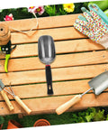 Ergonomic Metal Garden Shovel And Ice Scoop on wooden table surrounded by garden tools and gloves