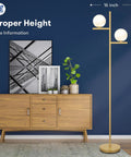 2 Globe Modern Floor Lamp With Foot Pedal Frosted Glass Shades Brass Gold Finish Tall Standing Pole Light next to a cabinet