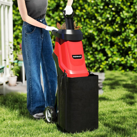 Person using Powerful 15 Amp Corded Wood Chipper Shredder With 15 To 1 Reduction, Plunger, Collection Bag, Wheel Kit in garden