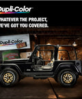 Side view of black Jeep in garage with Dupli-Color advertisement on the wall.
