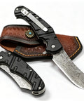 Beefy 67 Layer Damascus Steel Folding Pocket Knife With VG10 Core, G10 Handle, Flipper Opener And Clip For EDC, Camping, Hiking, And Hunting, Everyday Carry Ready And Sharp displayed with leather sheath