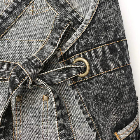 Close-up of the Denim Hair Stylist Tool Apron With Pockets for Women, showing black durable denim with cross back straps and button detail.