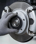Hand installing 4 Pack Black Hub Centric Rings 60.1 To 73.1 Mm Wheel Centerbore Fillers on a brake system.